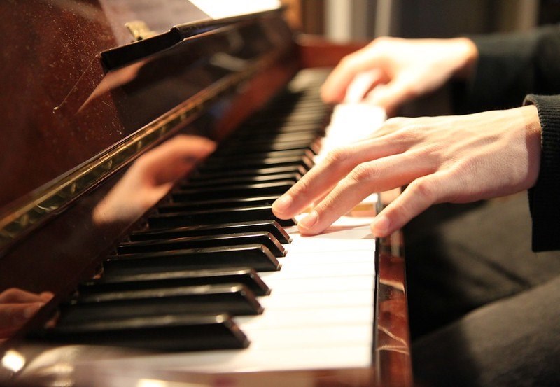 Close-up image of hands gracefully playing the piano, showcasing the artistry and skill of the pianist in action.