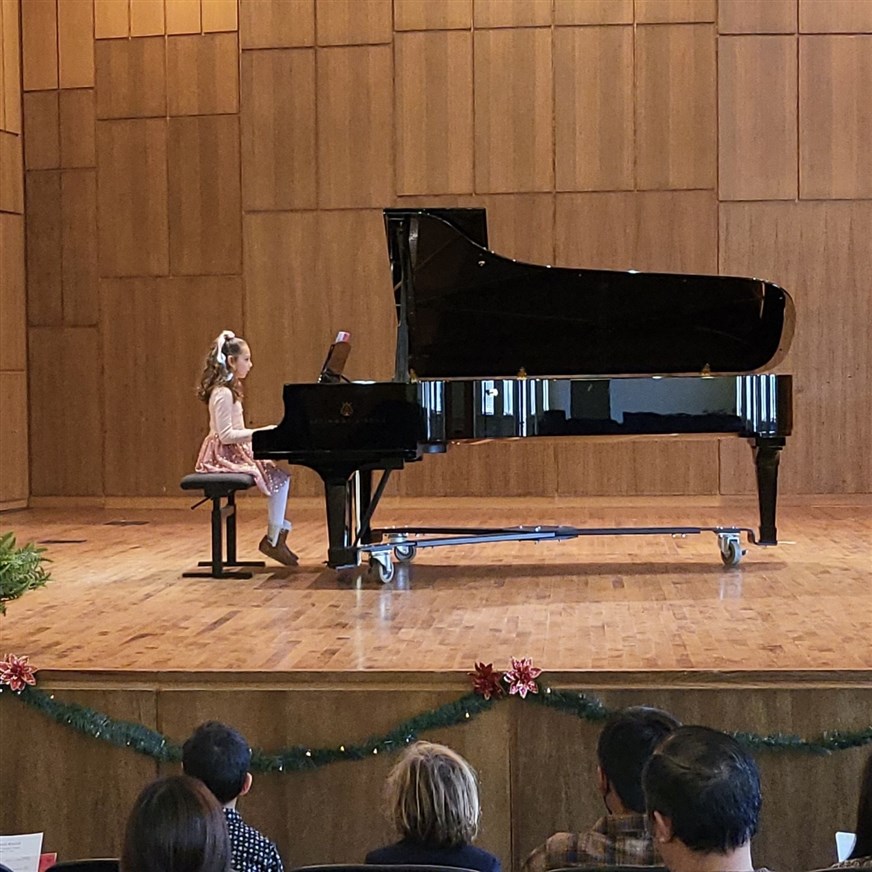 Captivating image of a student delivering a remarkable performance on stage in a world-class concert hall in Fort Worth. The student exudes talent and passion while sharing their musical artistry with the audience.