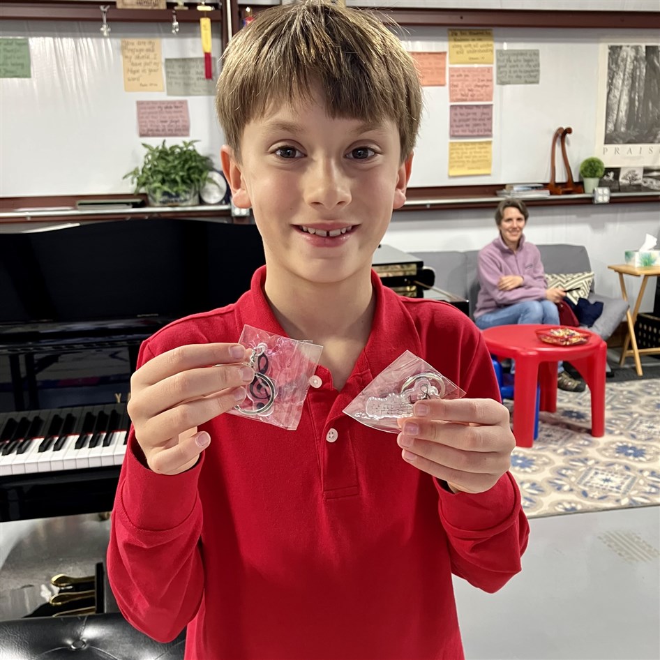 An image of a student proudly displaying prizes after winning the practice challenge, celebrating their dedication and success in musical achievement.